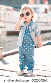 Stylish Baby Girl 2-3 Year Old Wearing Denim Clothes Outdoors. Looking At Camera. Summer Time. 