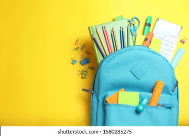 Stylish Backpack With Different School Stationery On Yellow Background, Flat Lay