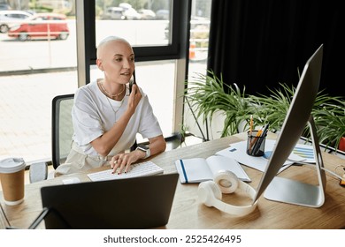 A stylish bald woman immerses herself in work, thoughtfully handling tasks at her desk. - Powered by Shutterstock