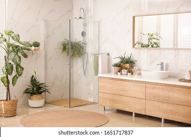 Stylish bathroom interior with countertop, shower stall and houseplants. Design idea - Shutterstock ID 1651717837