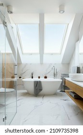 Stylish Bathroom Interior Design With Marble Panels. Bathtub, Towels And Other Personal Bathroom Accessories. Modern Glamour Interior Concept. Roof Window. Template.
