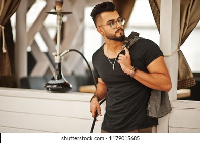 Stylish Beard Arabian Man In Glasses And Black T-shirt Smoking Hookah Outdoor. Arab Model Having Rest.