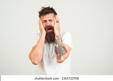 Stylish bearded man crying. Unhappy hipster guy man with tattoo, cry and have depression. Bearded man is stressed, on white background. Copy space. Sad expression, depression, despair concept