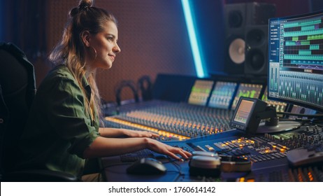 Stylish, Beautiful Female Audio Engineer Working in Music Recording Studio, Uses Mixing Board Create Song. Portrait of a Girl Artist Musician Working at Control Desk and Smiling - Powered by Shutterstock