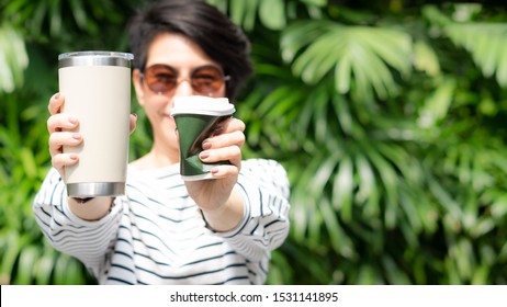 A Stylish Beautiful Woman Holding Takeaway Coffee Cup In Both Hands, One Is A Squeezed Single Use Paper Cup With Plastic Lid The Other One Is A Reusable Stainless Tumbler. No Straw, Say No To Plastic.