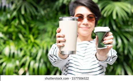 A Stylish Beautiful Woman Holding Takeaway Coffee Cup In Both Hands, One Is A Single Use Paper Cup With Plastic Lid The Other One Is A Reusable Stainless Tumbler. Say No To Plastic, No Straw, 0 Waste 