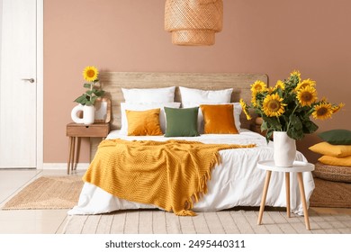 Stylish bedroom with big bed and vases of sunflowers bouquets on stool - Powered by Shutterstock