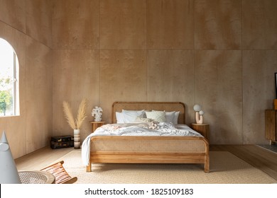 Stylish Bedroom corner with rattan headboard and bed with soft pillows setting with white pillows plywood wall on the background / cozy interior design / modern interior - Shutterstock ID 1825109183