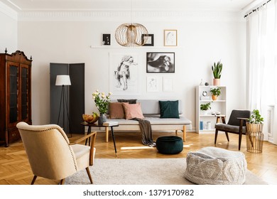 Stylische beige Sessel und Couch auf dem gemütlichen Teppichboden im eleganten Wohnzimmer mit grauem Sofa und Vintage-Möbeln
