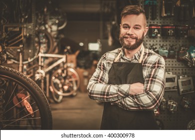 Stylish bicycle mechanic standing in his workshop.