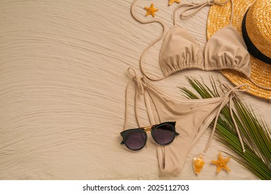 Stylish Bikini And Beach Accessories On Sand, Flat Lay. Space For Text