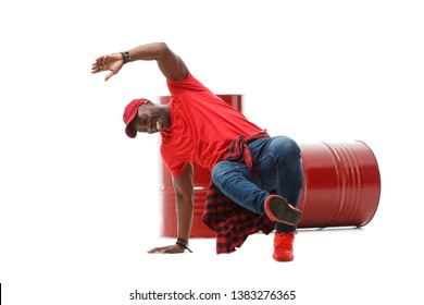 Stylish Black Guy In Red Clothes Dancing Break Dance Near The Barrel Isolated On White Background.