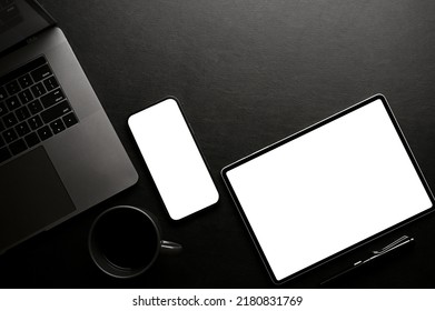 Stylish black office desk workspace top view, flat lay with smartphone and tablet white screen mockup, laptop computer, coffee cup and copy space. - Powered by Shutterstock