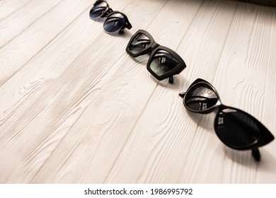 Stylish Black Sunglasses. Summer Background Mockup Template Text. Pattern Top View Above White Wooden Background. Summer Fashion Accessories For Beach. Women Summer Design Sunglasses. Vacation Concept