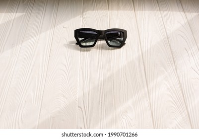 Stylish Black Sunglasses. Summer Background Mockup Template Text. Pattern Top View Above White Wooden Background. Summer Fashion Accessories For Beach. Women Design Sunglasses. Vacation Concept