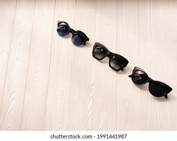 Stylish Black Sunglasses. Summer Background Mockup Template Text. Pattern Top View Above White Wooden Background. Fashion Accessories For Beach. Women Summer Design Sunglasses Vacation Concept