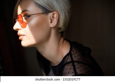 Stylish Blond Woman With Short Hair Cut With Trendy Red Sun Glasses. Beauty Blond Woman With Blue Eyes. Fine Art Portrait Of Blond Girl In Red Sun Glasses. Fashion Blogger Concept. Perfect Make Up 