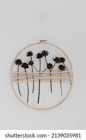 Stylish Boho Autumn Wreath With Dry Flowers. Wooden Hoop, Thread And Dry Herbs Wreath Hanging On White Wall. Modern Floral Arrangement And Creative Handmade Decor