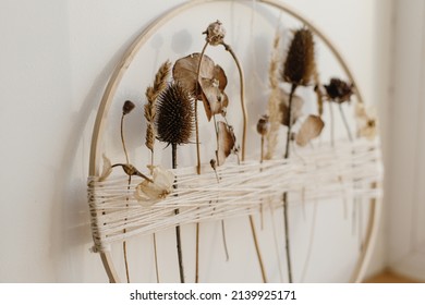 Stylish Boho Autumn Wreath With Dry Flowers. Wooden Hoop, Thread And Dry Herbs On White Wall Background. Modern Floral Arrangement And Creative Handmade Decor