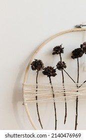 Stylish Boho Autumn Wreath With Dry Flowers. Wooden Hoop, Thread And Dry Herbs On White Wall Background. Modern Floral Arrangement And Creative Handmade Decor