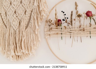 Stylish Boho Wreath With Dry Flowers And Macrame Hanging On White Wall. Modern Floral Arrangement And Creative Handmade Decor In Modern Boho Room