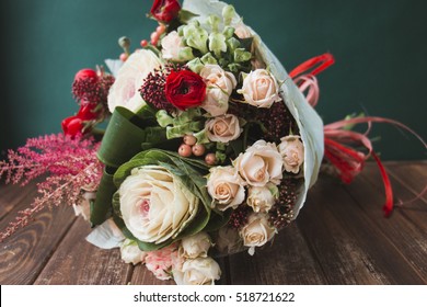 Stylish bouquet of red and green colors on a dark green background. Bouquet of brassica, rose and red ranunkulyus - Powered by Shutterstock