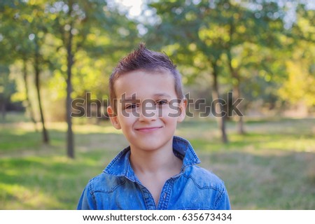 stylish boy with green eyes in the summer forest. the concept of a child's emotions
