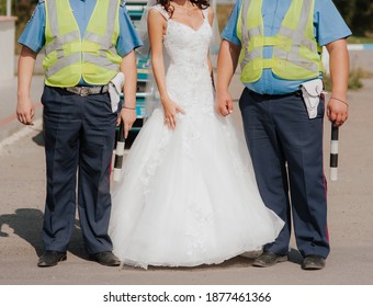 Stylish Bride Posing With Police Officers. Two Cops Join The Wedding Celebration.