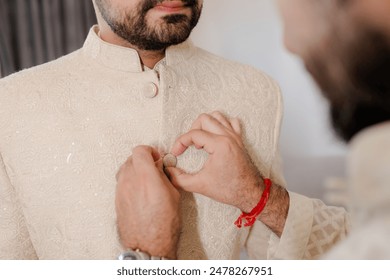 The stylish bridegroom dresses, prepares for the wedding ceremony. The groom's morning. Businessman wears a jacket, male hands closeup, groom getting ready in the morning before wedding ceremony
 - Powered by Shutterstock