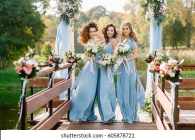 Stylish bridesmaids  having fun on nature dnym. Trendy wedding, same bridesmaids dresses