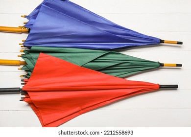 Stylish Bright Umbrellas On White Wooden Background