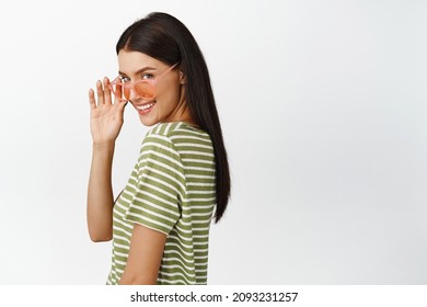 Stylish Brunete Woman In Sunglasses, Looking Flirty At Camera And Smiling, Smug Face, Standing Over White Background