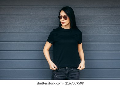 Stylish Brunette Asian Girl Wearing Black T-shirt And Sunglasses Posing Against Street , Urban Clothing Style. Street Photography