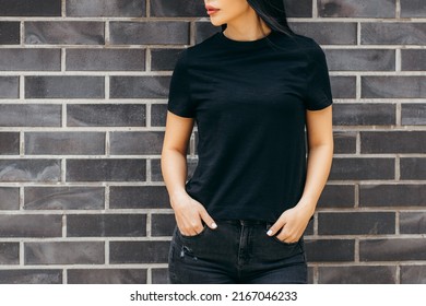 Stylish brunette asian girl wearing black t-shirt posing against street , urban clothing style. Street photography