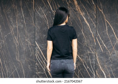 Stylish Brunette Girl Wearing Black T-shirt And Jeans Posing Against Street , Urban Clothing Style. Street Photography