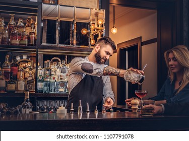 Stylish brutal barman serves an attractive couple who spend an evening on a date. - Powered by Shutterstock