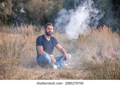 Stylish brutalsmoker blows up a couple an electronic cigarette in the fresh air. Vaping activity.