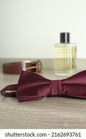 Stylish Burgundy Bow Tie On Wooden Table, Closeup