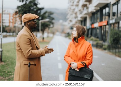 A stylish business couple of different ethnicities engage in a conversation while walking on a street, portraying work-life balance and partnership. - Powered by Shutterstock