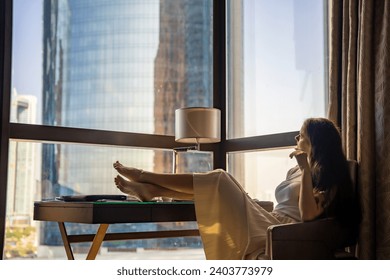 Stylish businesswoman freelancer working and she is laying on the chair, enjoying panoramic view in the city background. Low key photo. High quality photo - Powered by Shutterstock