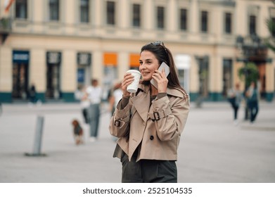 Stylish businesswoman strolls through the city, sipping coffee, talking on the phone, exuding confidence and professionalism - Powered by Shutterstock