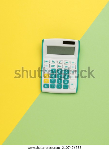 Stylish calculator\
on a yellow and green background. A device for computing. Minimal\
accounting concept.