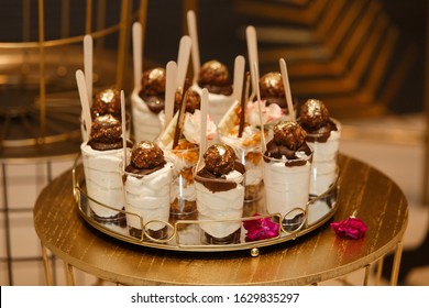 Stylish Candy Bar On The Birthday Or Wedding Festive Party Close Up. Sweets And Delisious Desserts On A Festive Table Decorated With Flowers. Set Of Ice Cream Glass Cups Decorated  With Caramel