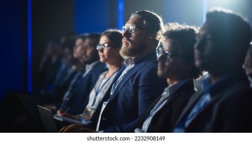 Stylish Caucasian Man Sitting in a Crowded Audience at a Political Rally. Corporate Delegate Taking Notes in a Laptop. Government Employee Attending Ministry Policy Makers Conference. - Shutterstock ID 2232908149