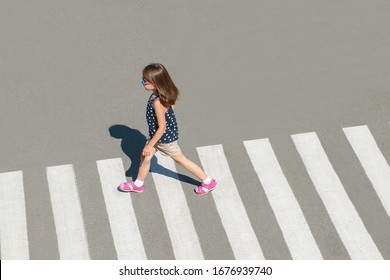 Stylish Child In Glasses, Fashion Clothes Walking Along Summer City Crosswalk. Kid On Pedestrian Side Walk. Concept Pedestrians Passing A Crosswalk. From Top View. Shadow At Zebra Crossing