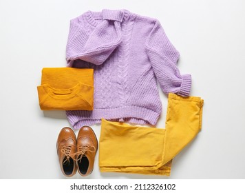 Stylish children's clothes and shoes on white background