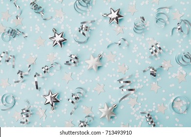 Stylish christmas background with confetti, serpentine and silver stars top view. Flat lay