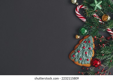 Stylish christmas cookie, tree branches, candy cane, festive decorations border on black background. Modern christmas flat lay, space for text. Season's greetings card. Merry Christmas! - Powered by Shutterstock