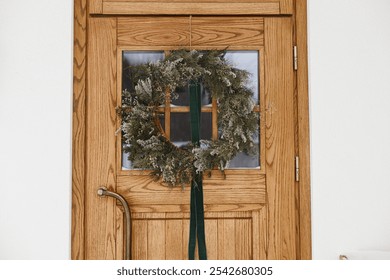 Stylish christmas rustic wreath with ribbon hanging on wooden doors, close up. Modern farmhouse entrance decoration for winter holiday. Merry Christmas and Happy holidays - Powered by Shutterstock