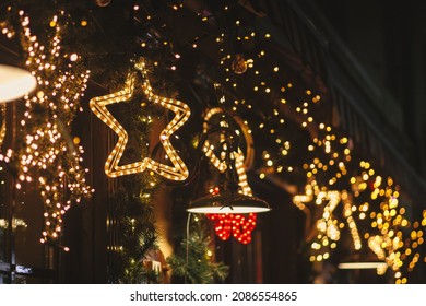 Stylish christmas star illumination and spruce branches in golden lights in evening, fairytale decoration. Atmospheric magic time. Christmas festive decor for winter holidays. Merry Christmas! - Shutterstock ID 2086554865